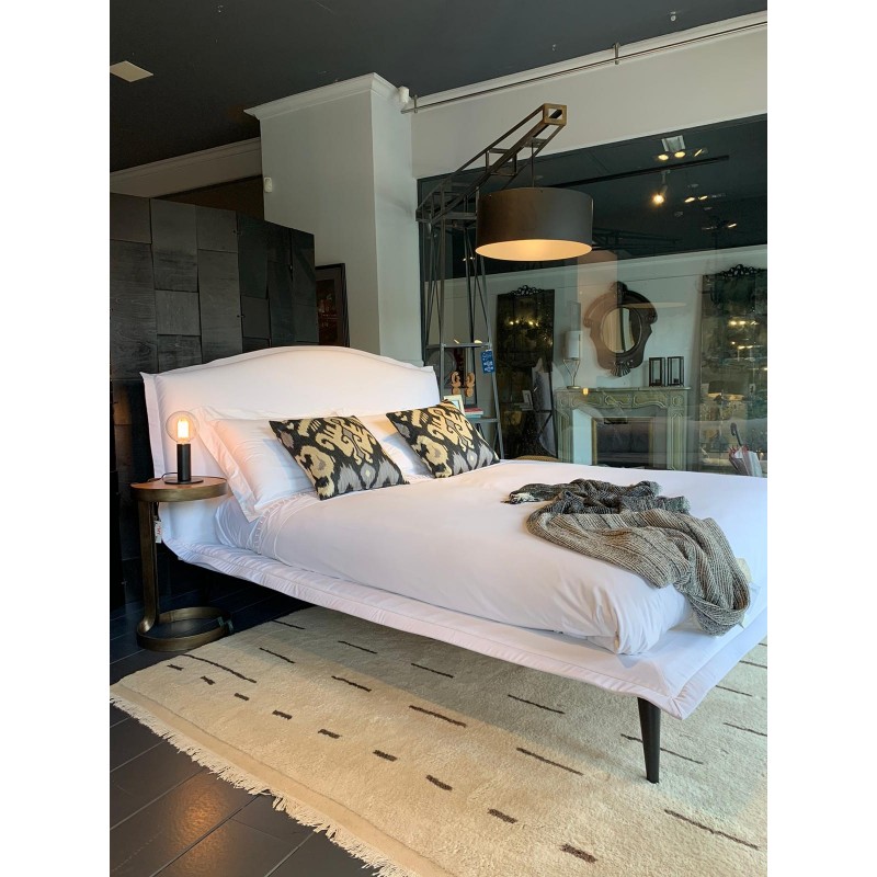 cama tapizada en blanco de Noctis